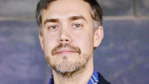 Close portrait of a man's face, looking earnest.