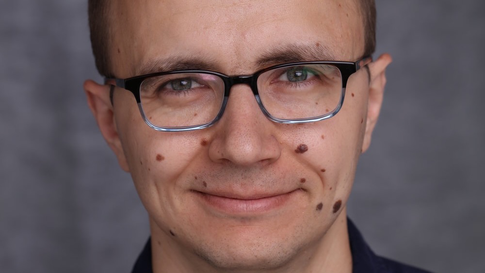 Professional headshot of a man's face, close up.