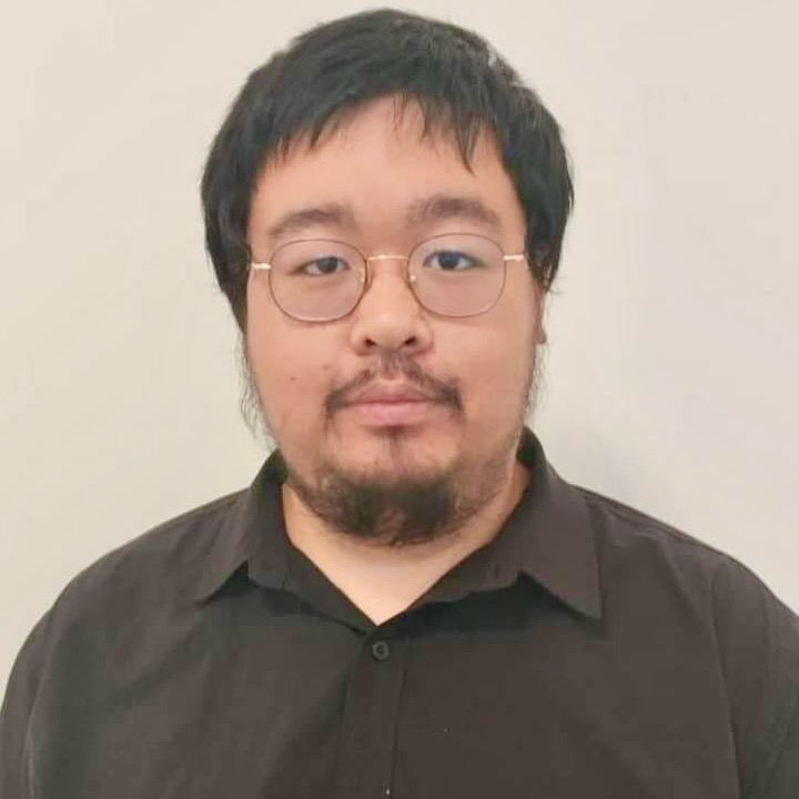 Portrait of a young man with glasses wearing a black shirt.