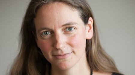 Close professional portrait of a woman with long hair.