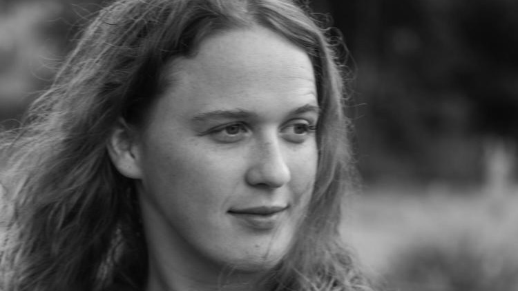 A black-and-white three-quarters portrait of a young woman.