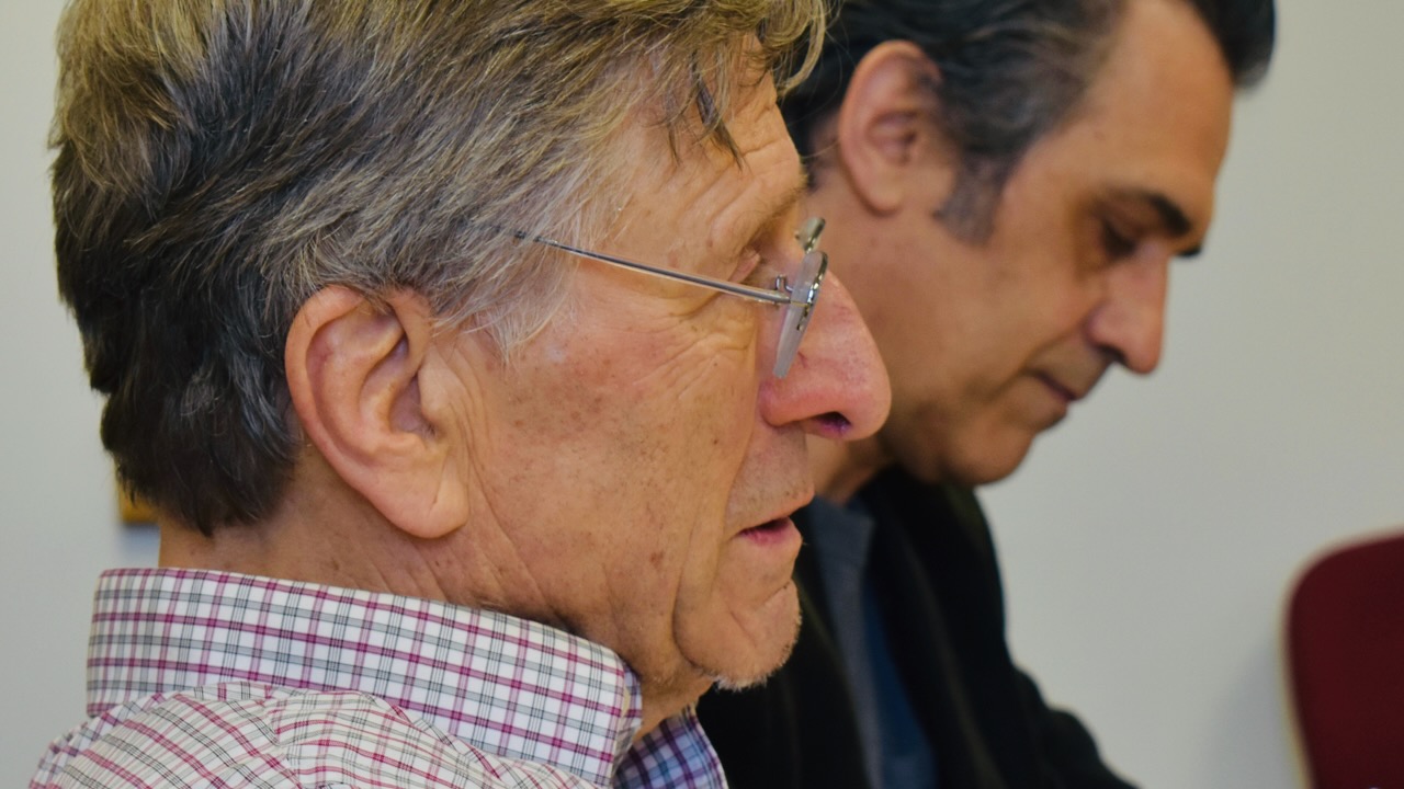 Two men in profile, concentrating.