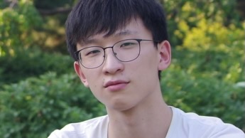 Close portrait of a young man, sitting outside.