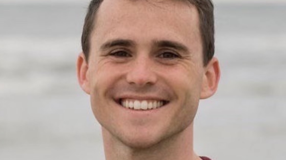 A young man smiling.