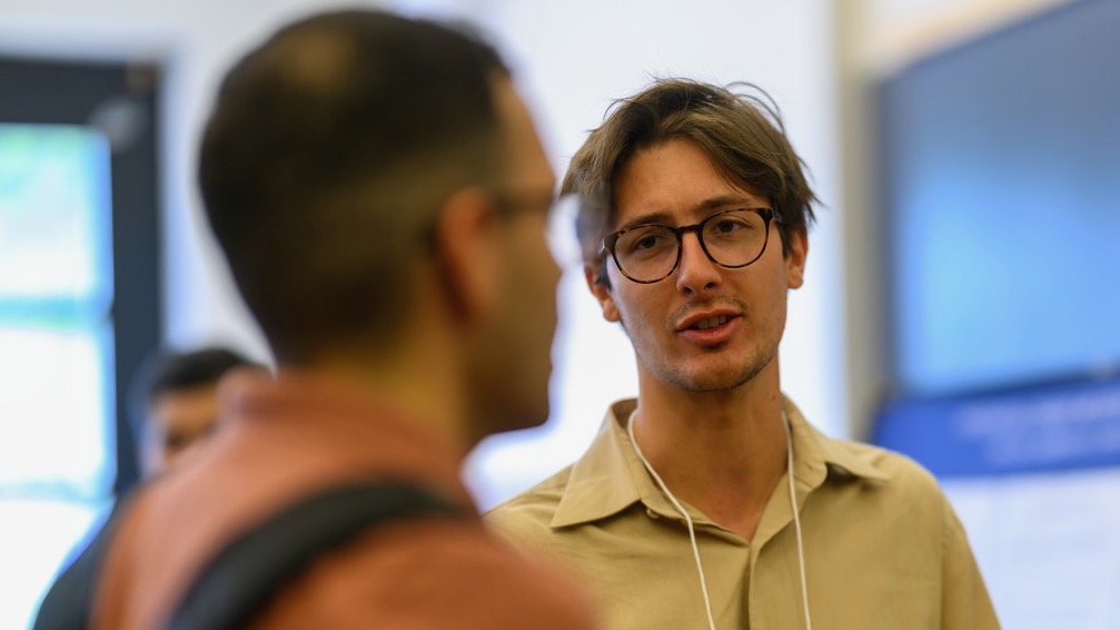 A man presenting a conference poster. 